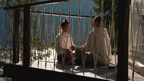 couple meditating on a deck overlooking a lake