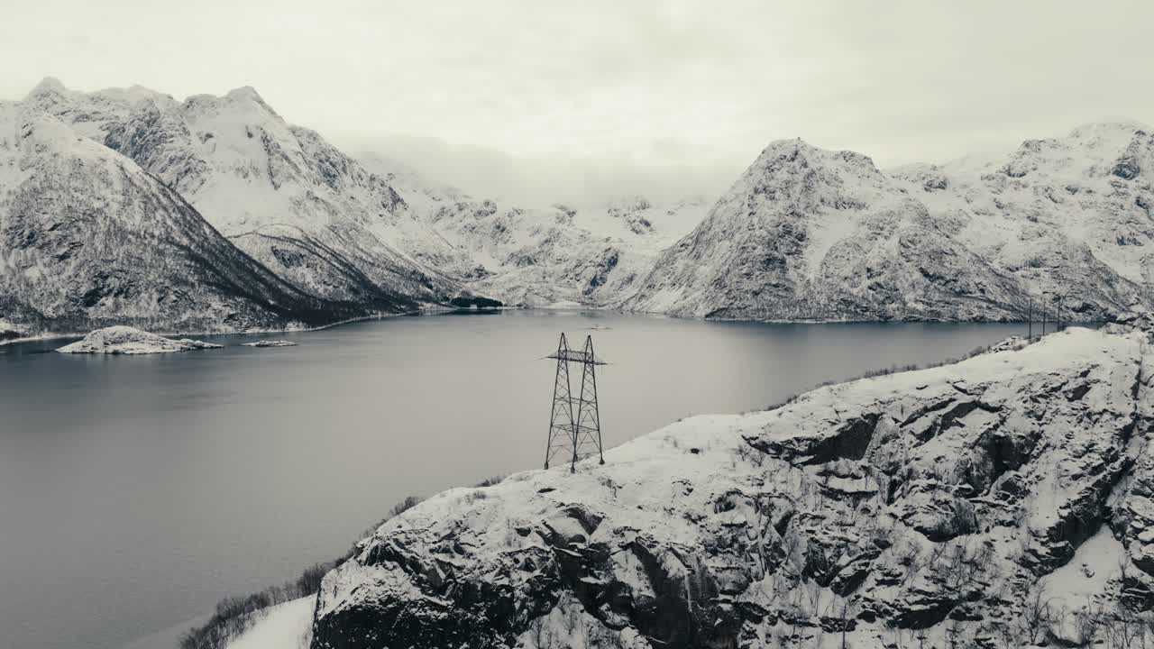 Electrical Transmission Tower Over The Rocky Mountains During Winter Near Svolvaer, Norway. Aerial Shot