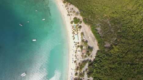 vista aérea girando sobre una playa de arena blanca y caminos en la ladera en st thomas, ee.uu. - ojo de pájaro, disparo de drones
