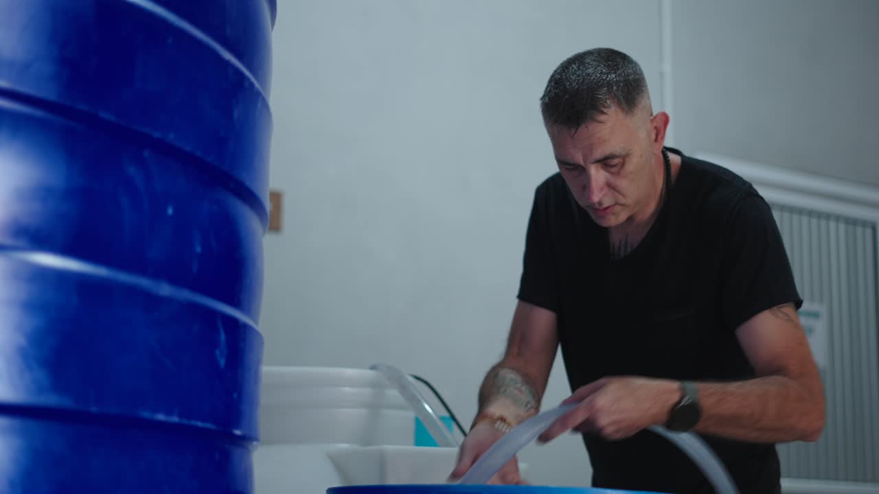 Man Working with Water Tanks and Piping