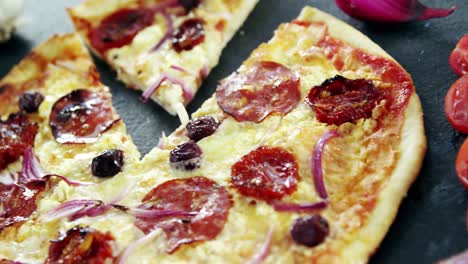 pizza italiana en una mesa de madera con verduras y especias