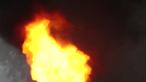 a large, intense flame is visible burning within a furnace, seen through a narrow slit