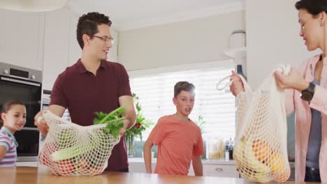 Familia-Caucásica-Feliz-Desempacando-Bolsas-Con-Verduras