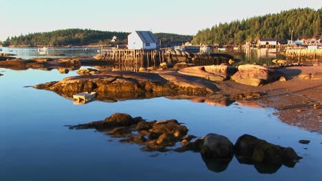 a lobster village building over water as seen from a rocky shore in stonington maine