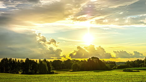 golden sunrise behind cumulus clouds over countryside nature