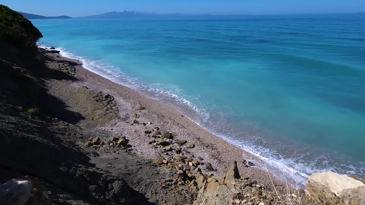 Marina blu con mare aperto e costa rocciosa nel Mediterraneo, splendido sfondo panoramico estivo.