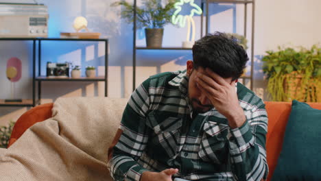 sad indian man use smartphone surprised by bad news fortune loss fail lottery results deadline