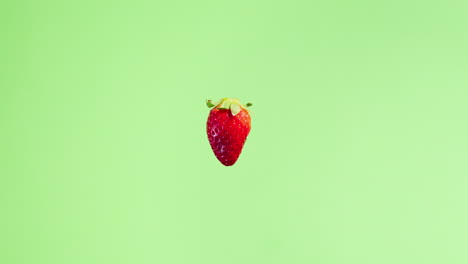 4K-stop-motion-video-of-a-fresh-strawberry-getting-bigger-in-the-frame-with-green-background