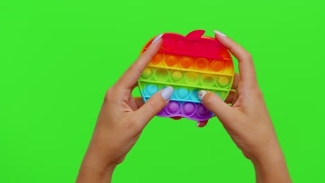 girl hands playing with pop it sensory anti-stress bubbles squish toy game isolated on chroma key