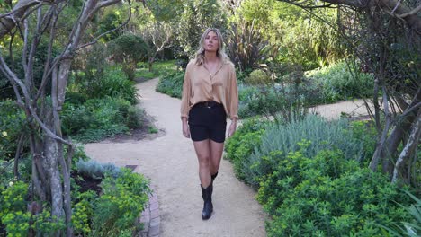 Young-woman-walks-through-wooden-archway-in-garden_slow-motion