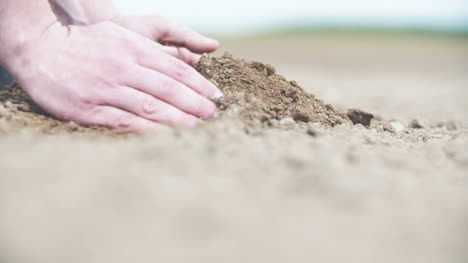 Farmer-Hands-Holding-And-Pouring-Back-Organic-Soil-On-Sunrise-Light