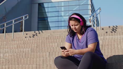 Mujer-Usando-Teléfono-Móvil-Después-De-Un-Duro-Entrenamiento