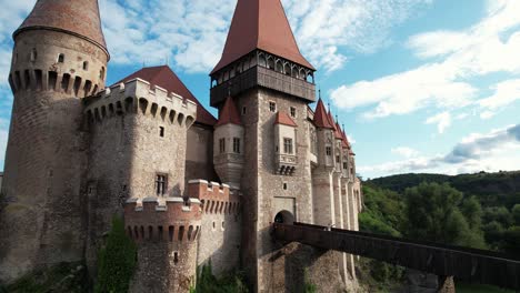 dramatic drone rise beneath corvin castle in romania. gothic fortress from below. epic cinematic shot of medieval landmark in 4k.