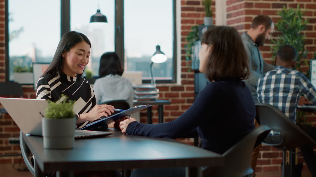 Asian worker greeting female applicant at job interview