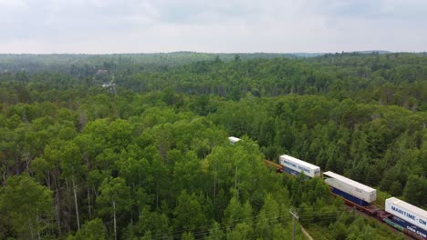 railway train cars loaded with containers shipped from overseas wind its way through the canadian wilderness