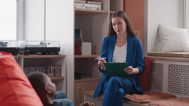 Psychologist conducts therapy session for married couple in office. Positive woman in blue suit consults young family at appointment. Mental health