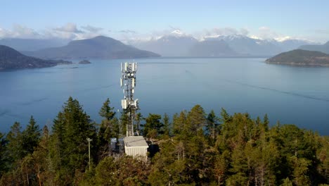 sitio de célula altísima en un entorno verde con paisaje marítimo plácido y vista distante de la montaña en la bahía de la herradura, bc, oeste de vancouver, canadá