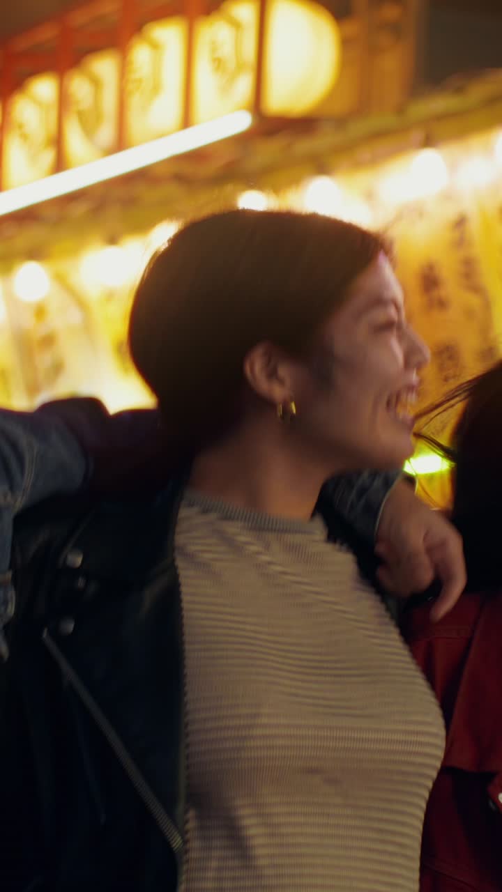 Happy friends enjoying a night out in a Japanese market