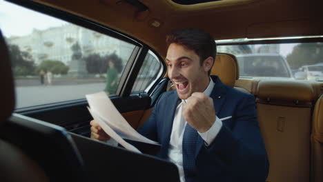 hombre de negocios feliz deleitando con excelentes datos en el coche moderno. hombre en el coche