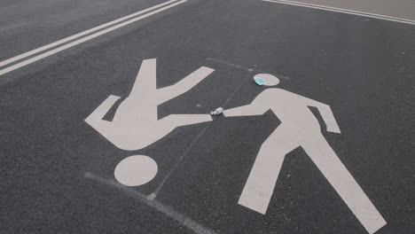 static shot of painted pedestrian symbols on road surface with surgical mask and hand sanitizer, central park, new york city