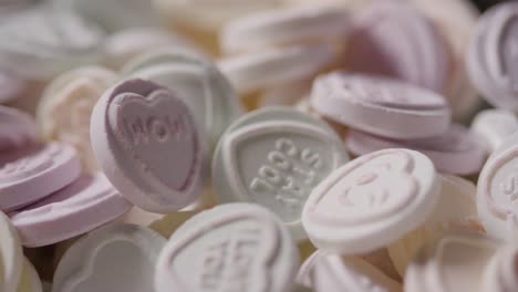 Close-Up-Of-Heart-Candy-With-Romantic-Messages-Of-Love-In-Bowl-On-Blue-Background