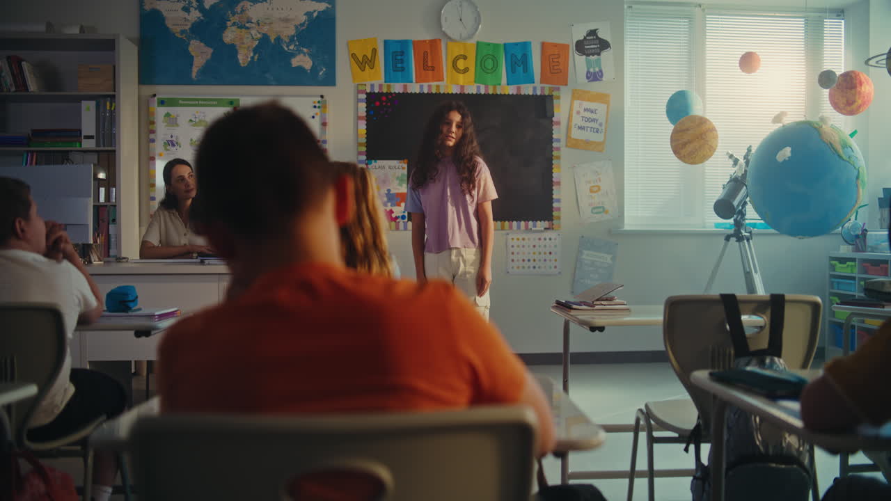 Primary School Girl Showcasing Knowledge of Geography in Front of Class and Teacher Using Digital