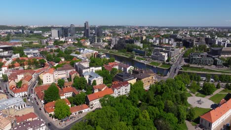 drone flying away from neris river in vilnius, lithuania on summer day