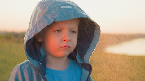 abandoned child expression against sunset disappointed boy rainsoaked and weary stands alone on