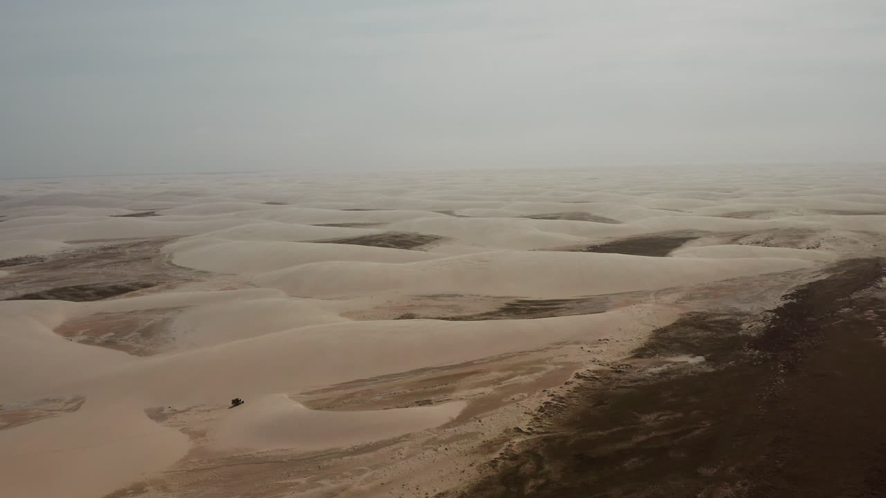 antena: un camión con kitesurfistas viajando a través de las dunas de lencois maranhenses en brasil, durante la estación seca