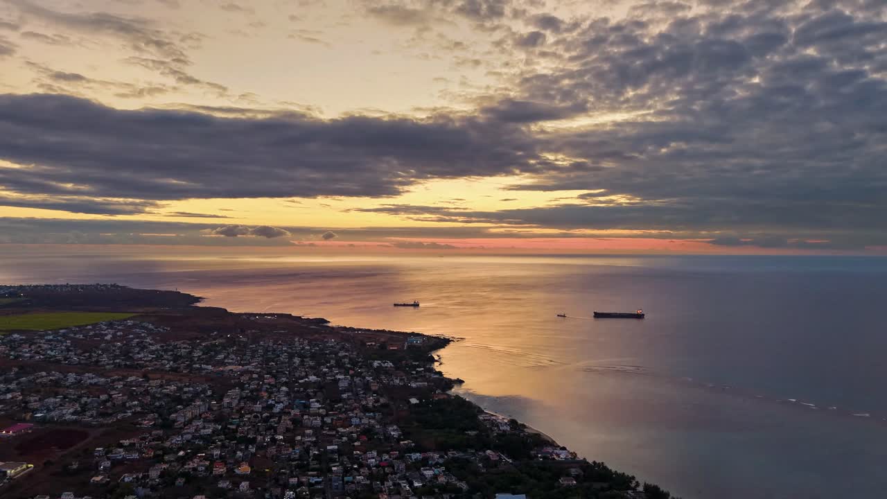 Sunset aerial time-lapse of Oil tankers anchored off the Mauritius coastline, reflecting warm light across the tranquil ocean