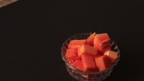 papaya slice and papaya juice on green leaf and black background, healthy and diet fruit