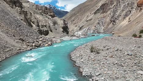 aerial drone shot capturing turquoise river waters flowing past a historic mountain monastery.