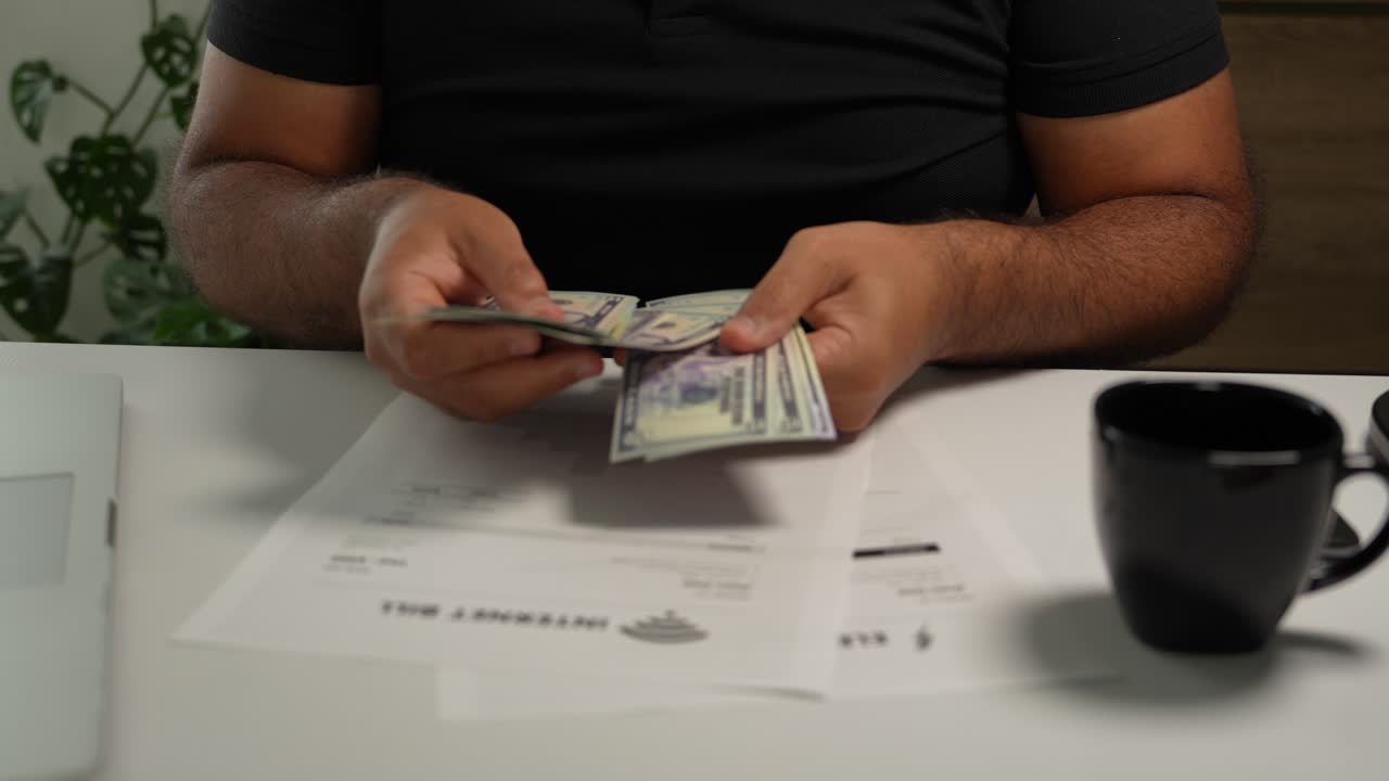 Close-up Unrecognizable Hispanic Man Counting Money to Pay Bills on Table