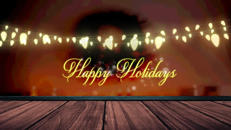 animation of fairy lights and happy holidays text over wooden boards