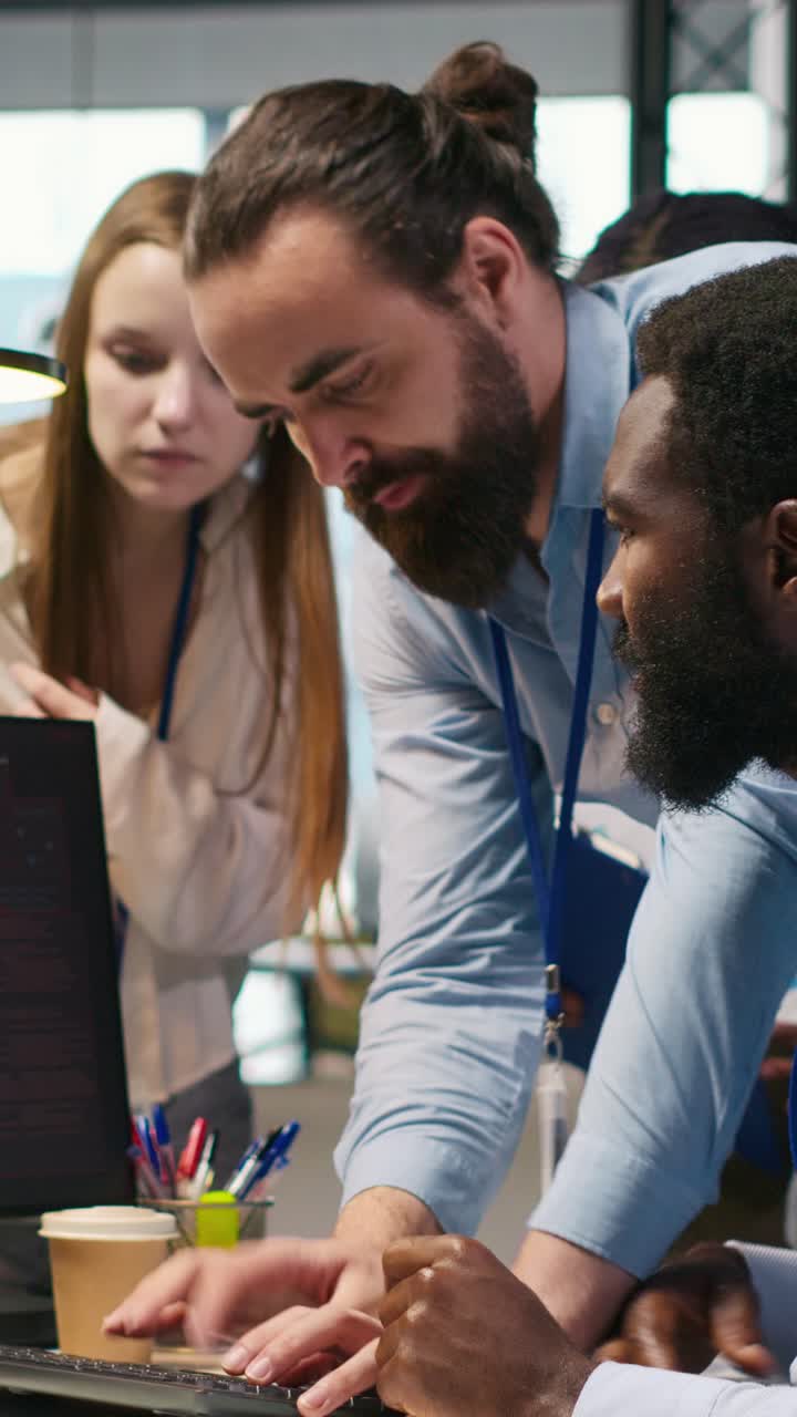 Vertical video Programmer in office requesting help from coworkers to fix critical error