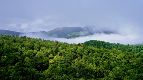 cinematic aerial view of fog softening mountain outlines