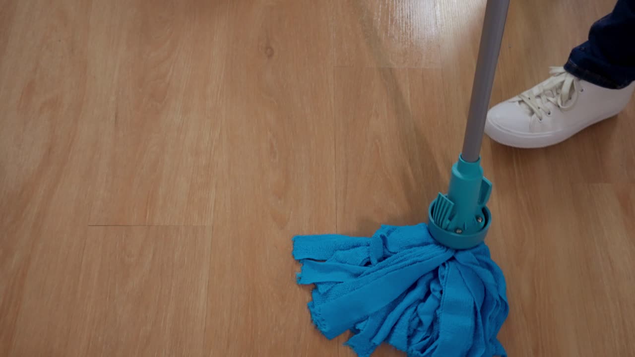 Cleaning parquet floors with a blue mop