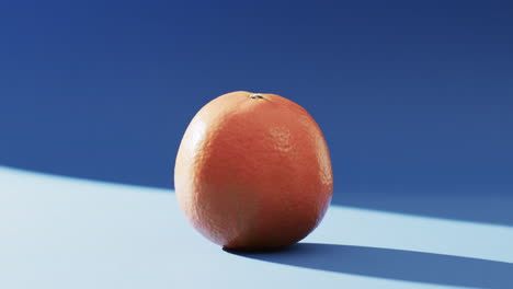 video of close up of orange with copy space over blue background