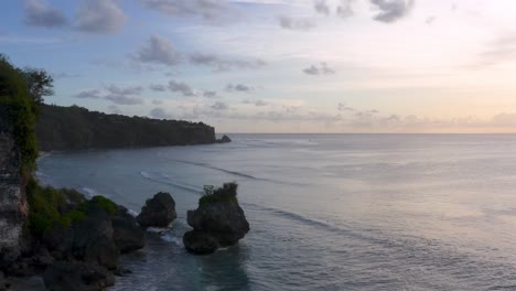 aerial push-out of cliffs, forest, beach, and open sea in indonesia