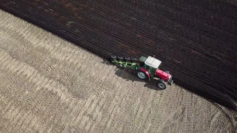 aerial footage over tractor ploughing field