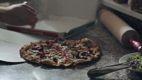 cook preparing pizza for delivery on kitchen