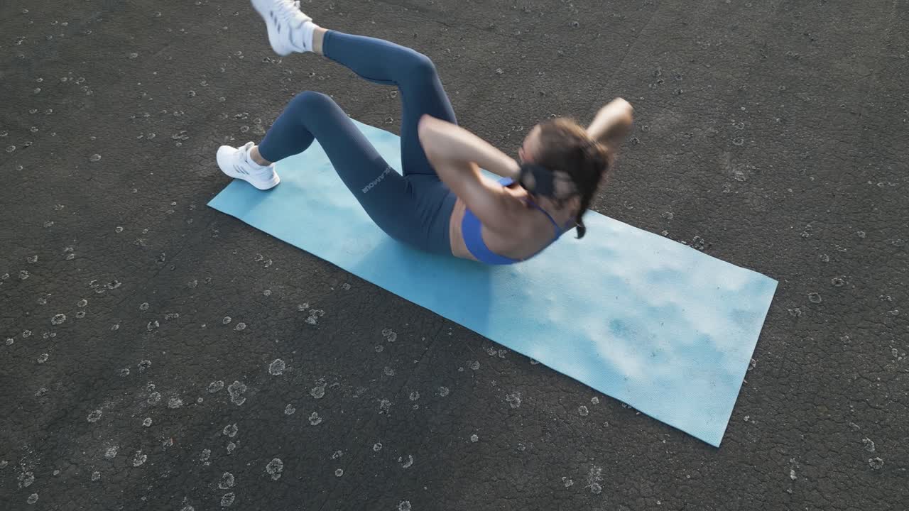 una mujer en forma hace abdominales cruzados