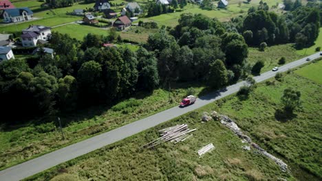 Aerial-Shot-of-Small-Fire-Truck-Driving-the-Lonely-Road-in-Village