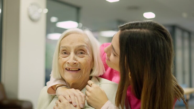Elderly woman receiving care and affection from a caregiver