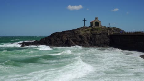 strong waves crash into the beach and coastal defenses of collioure in the mediterranean coast in the south of france during a very strong wind storm