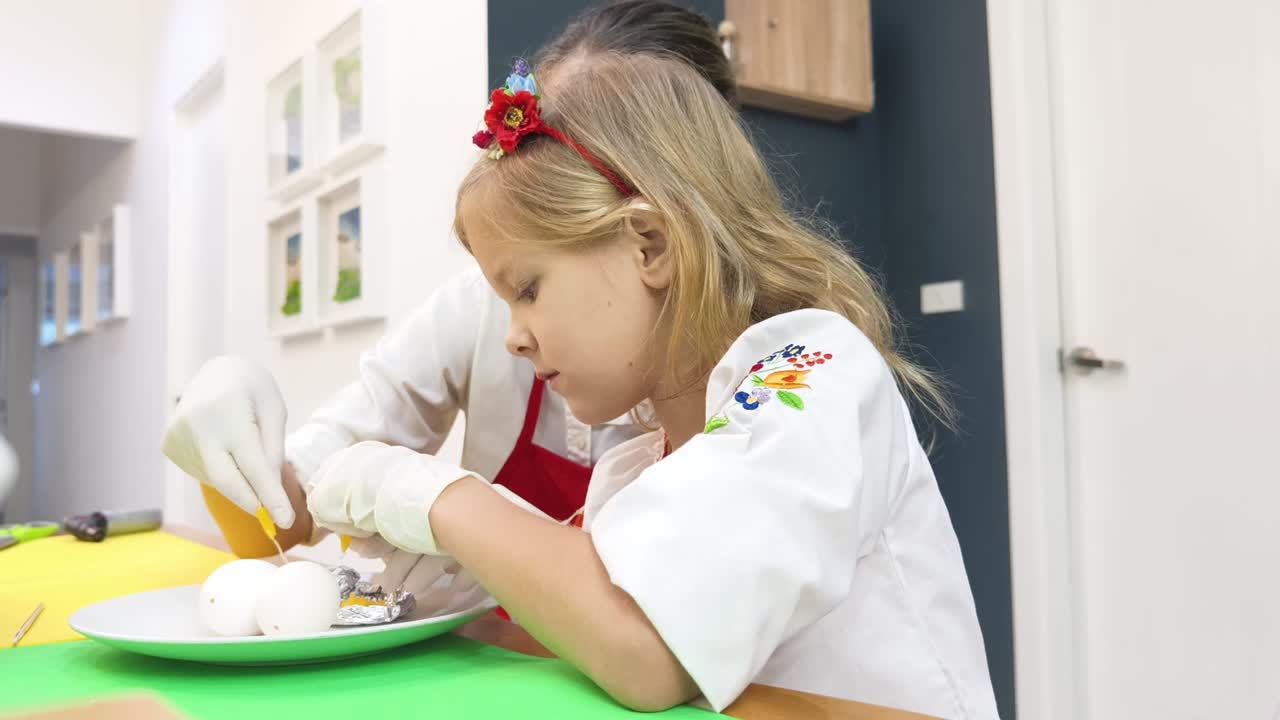 Bambino e adulto che decorano uova di Pasqua