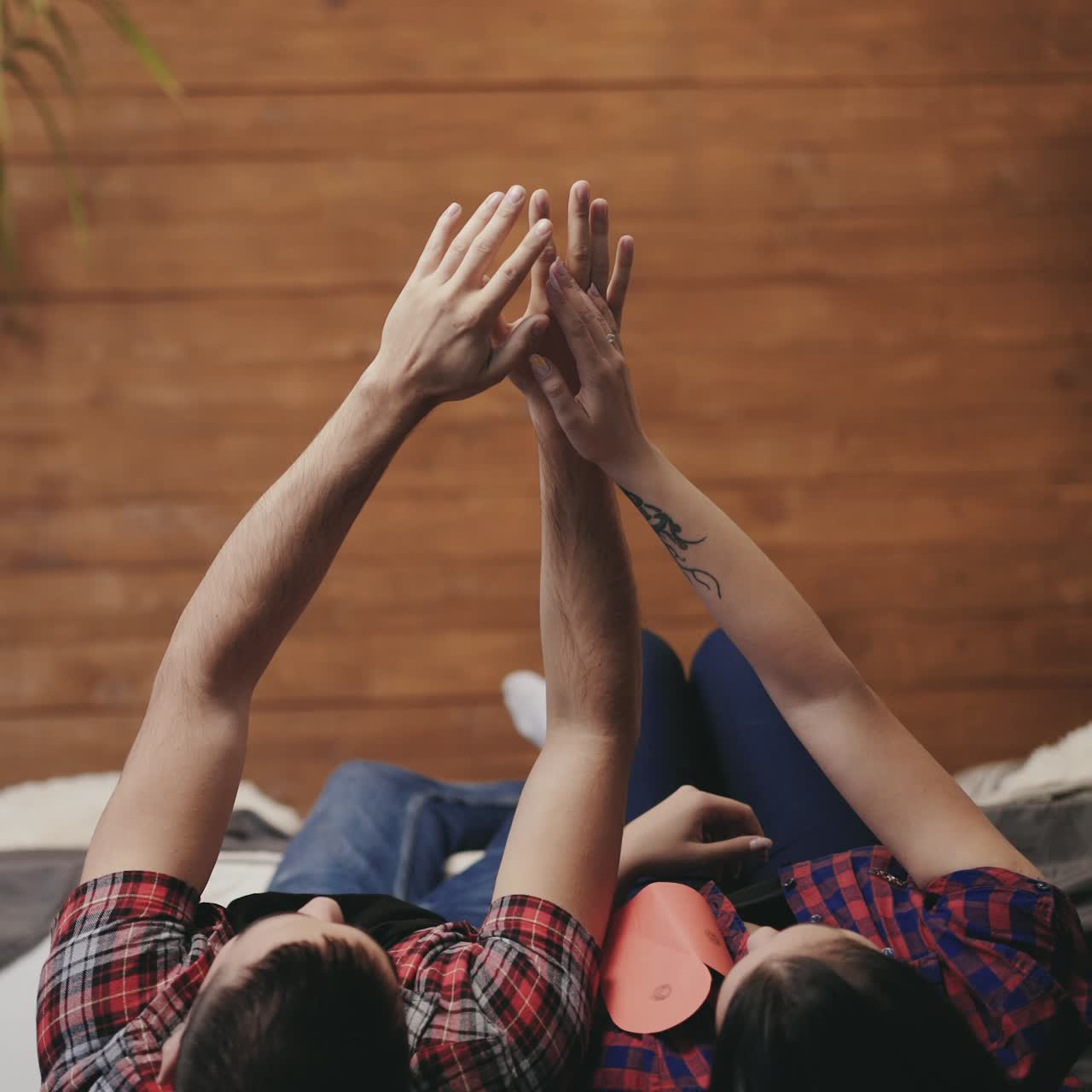 enamored man and woman are throwing down hearts handmade out of their hands on the bed together on Valentine's Day