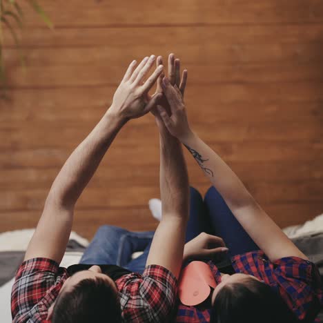 enamored man and woman are throwing down hearts handmade out of their hands on the bed together on valentine's day