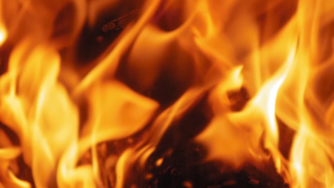 llama ardiente en la chimenea en troncos de madera