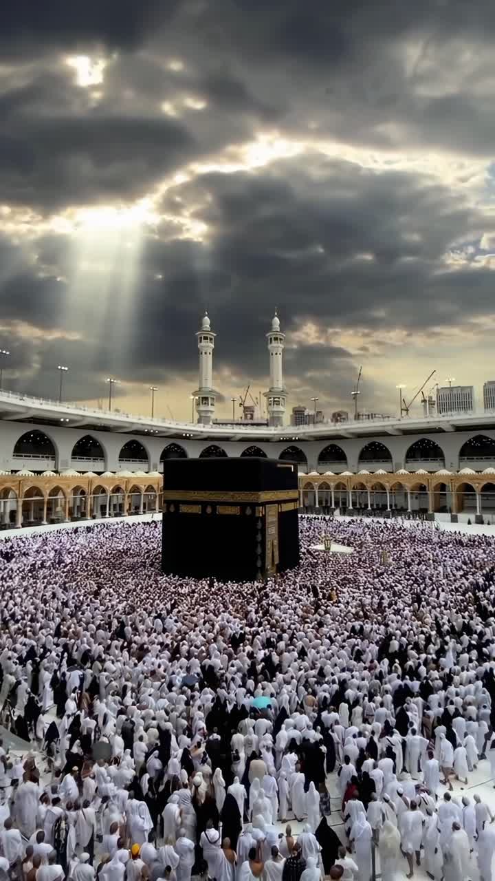 Vista de video aérea de una vasta multitud vestida de blanco rodeando una estructura central bajo cielos dramáticos